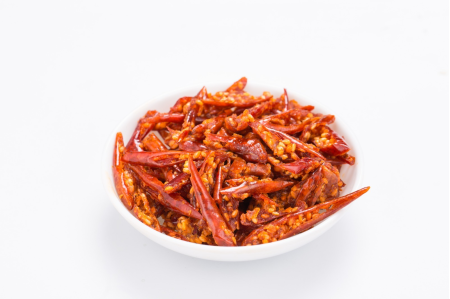 Close-up of crispy chili pepper slices with sesame in a white bowl